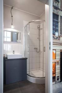a bathroom with a glass shower and a sink at Good Time Residence in Łódź