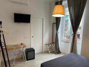 um quarto com uma cama, uma secretária e uma janela em San Martino Rooms Third Floor No Lift em La Spezia