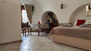 - une chambre avec 2 lits, une table et une salle à manger dans l'établissement La Locanda di Nonno Paolo, à Altamura