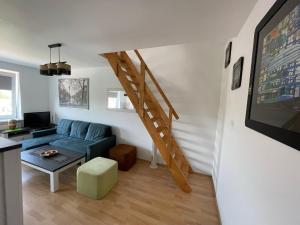 ein Wohnzimmer mit einem blauen Sofa und einer Treppe in der Unterkunft Apartament Bea Mar in Gdynia