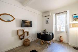 a living room with a table and a window at Chez Jude in Cannes