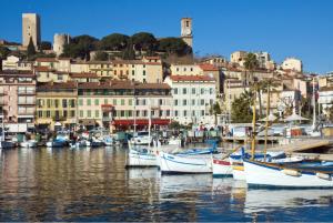 eine Gruppe von Booten, die in einem Hafen mit Gebäuden angedockt sind in der Unterkunft Chez Jude in Cannes