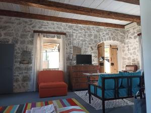 a living room with a bed and a tv at 19th century stone house on the seashore in Radovići