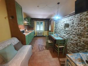 cocina con mesa y pared de piedra en Da Nonna Mafalda near 5 terre, en Brugnato