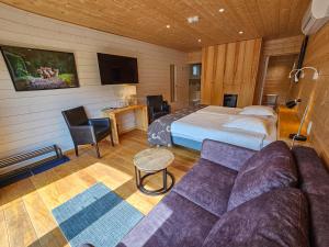 une chambre d'hôtel avec un lit et un canapé dans l'établissement Logis Hôtel Le Menobu, à Theux