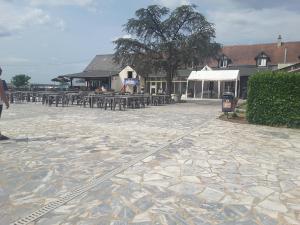 a patio with tables and chairs and a building at mobilhome JENNYFER et LOGAN in Onzain