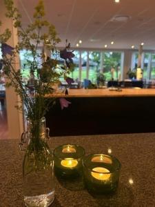 a table with two candles and a vase with lights at Sotenäs Golfhotell in Hunnebostrand