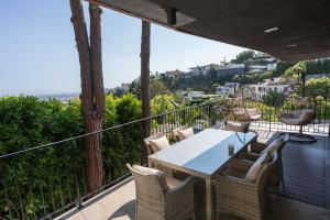 a patio with a table and chairs on a balcony at Urban Oasis: Stylish Mid-Century Home in Weho in Los Angeles