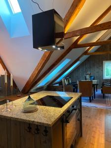 an attic kitchen with a stove and a living room at Storsand Gård in Trondheim