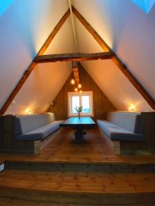 a room with a table and couches in a attic at Storsand Gård in Trondheim