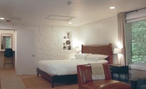 a bedroom with a bed and a chair and a window at Hotel Cashiers in Cashiers