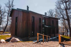 uma pequena casa de madeira com escadas em frente em El Refugio Ski & Summer Lodge em San Martín de los Andes