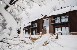 a lodge in the snow with snow covered trees at El Refugio Ski & Summer Lodge in San Martín de los Andes