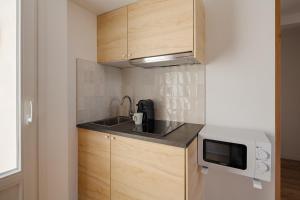 a small kitchen with a sink and a microwave at Sonder Quintinie in Paris