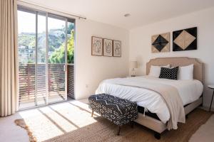 a bedroom with a bed and a large window at Urban Oasis: Stylish Mid-Century Home in Weho in Los Angeles