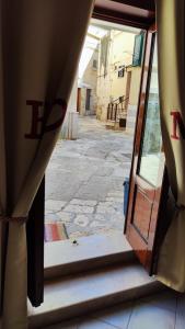 une porte ouverte d'un bâtiment avec une rue vide dans l'établissement La Locanda di Nonno Paolo, à Altamura