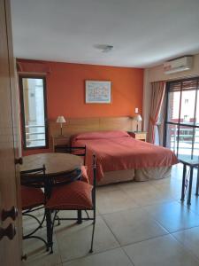1 dormitorio con 1 cama, mesa y sillas en Maison Apart Hotel en Mar del Plata