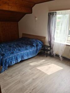 Un dormitorio con una cama azul y una ventana en appartement 3 pce, 