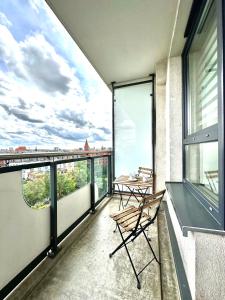 - un balcon avec une table et des chaises dans un bâtiment dans l'établissement PODWALE 2 Apartment - Self Check-In 20h ~Parking & Lift, à Wrocław