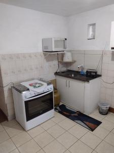 a kitchen with a stove and a microwave at Casa no Centro em DM - 500 metros rua de lazer in Domingos Martins