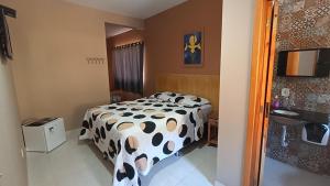 a bedroom with a bed with a cow print sheets at Pousada Alejandro in Cunha