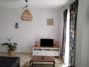 a living room with a tv on a white cabinet at Perfecta ubicacion para disfrutar de la ciudad in Tarifa +2 photos