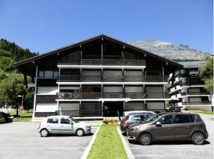 two cars parked in a parking lot in front of a building at Montagne aux Contamines Montjoie Appartement 6-7 personnes in Les Contamines-Montjoie +1 photo