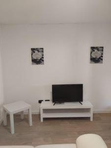 a living room with a tv on a white wall at LANZO IN CORTE APPARTAMENTO in Lanzo dʼIntelvi