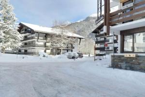 a snow covered street in front of a building at Montagne aux Contamines Montjoie Appartement 6-7 personnes in Les Contamines-Montjoie