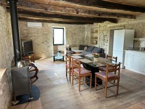 uma cozinha e sala de estar com uma mesa e um fogão em Maison charmante nature piscine chauffée em Montlauzun