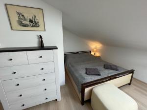 a small bedroom with a bed and a dresser at Apartament Bea Mar in Gdynia