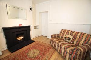 a living room with a couch and a fireplace at City Centre Townhouse in Galway