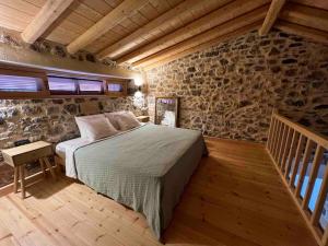 a bedroom with a bed and a stone wall at Luxury Historic Island Home with Private Garden in Poros