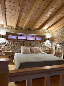 a bedroom with a bed in a stone wall at Luxury Historic Island Home with Private Garden in Poros