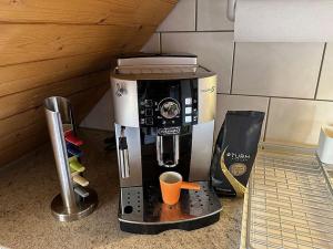 - une cafetière avec une tasse sur un comptoir dans l'établissement Hadassa Apartment Simcha, à Niederwichtrach