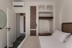 Kakóvolon的住宿－Fos Suites，卧室配有白色的床和衣柜。