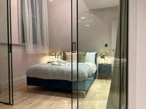 1 dormitorio con 1 cama y pared de cristal en Bella Ruiz Penthouse in Manchester city centre en Mánchester
