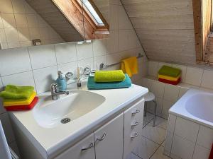 a bathroom with a sink and green towels on the counter at Hadassa Apartment Simcha in Niederwichtrach