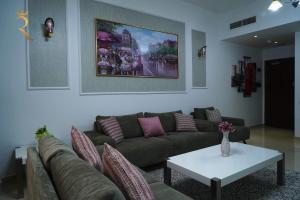 a living room with a couch and a table at Azure Bliss - Cozy 1BR Haven in Baniyas, Near Baniyas Square in Abu Dhabi