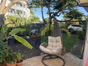 a swing chair sitting on a patio at Ti Kaz Lo Ker chambre d'hôte chez l'habitant in Saint-Joseph