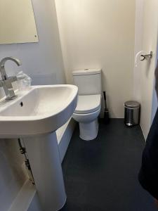 a bathroom with a white sink and a toilet at Headlands - Room Only Accommodation in Falmouth