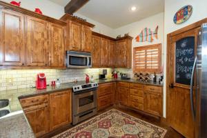 a kitchen with wooden cabinets and a stove top oven at Luxurious, Tranquil, 4BR Lakefront Villa in Mabank