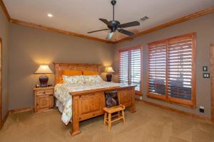 a bedroom with a bed and a ceiling fan at Luxurious, Tranquil, 4BR Lakefront Villa in Mabank