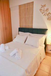a large white bed with two white towels on it at 22 Apartment with private parking in Larisa