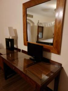 a desk with a computer on it with a mirror at Suite Elisir Domina Coral Bay in Sharm El Sheikh