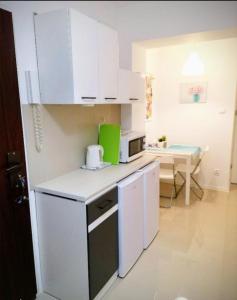 a small kitchen with white cabinets and a table at Ursus Rooms-Self Check-in in Warsaw