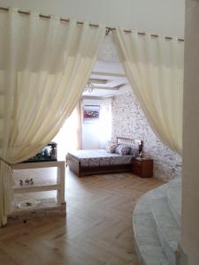 'Aïn TayaにあるLa perlaのカーテン付きのベッドルーム1室(ベッド1台付)