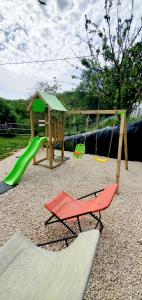 a playground with a slide and a swing set at -WOOD- Appartement meublé cosy & confort-Parking privé & jardin in Laveyron