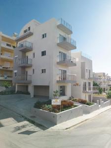 a white apartment building with balconies on a street at EDEL Luxury Apartments in Chania Town