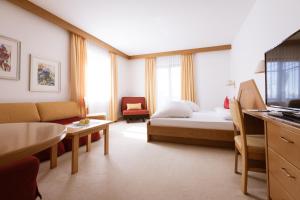 une chambre d'hôtel avec un lit et un salon dans l'établissement B&B Hotel Mair am Turm, à Tirolo